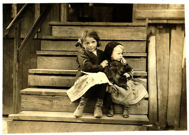 Little Julia tending the baby at home. All the older ones are at the factory. She shucks also. Alabama Canning Co.,. Location: Bayou La Batre, Alabama. Photograph by Lewis Wickes...