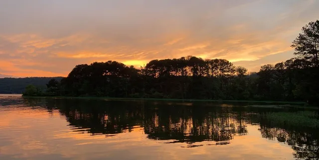 A photo of the sun setting over an island in the Coosa River located in Southside, Alabama.