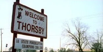 Thorsby's town sign displaying the local high school's mascot, the Rebel Man.