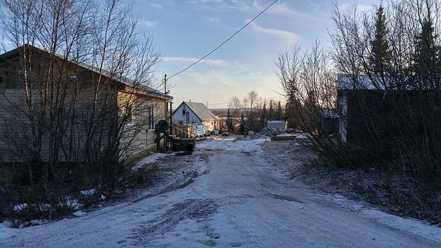 A street level view of New Stuyahok, Alaska around noon on 12-Jan-2016. Visible are some typical homes and outbuildings.