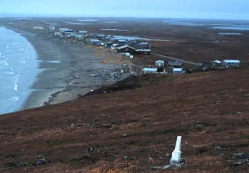 View of the Wales Site , a National Historic Landmark District near Wales , Alaska , United States , with the city of Wales visible in the background.