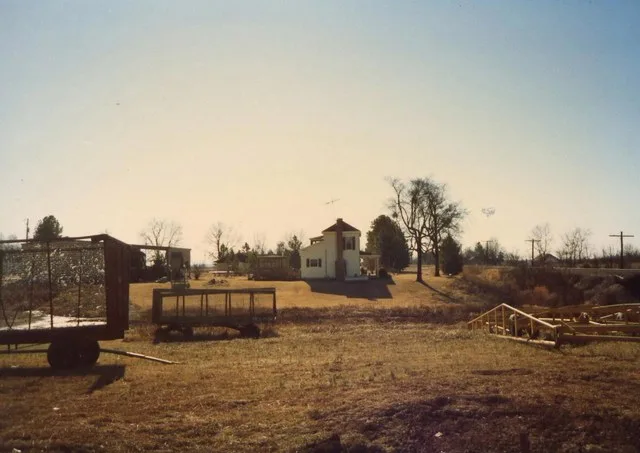 Winchester, Arkansas 1989. House, farm equipment. This was the Collins-Morris house built in 1868, seen from across Bayou Bartholomew. It was destroyed by fire in March 2026.