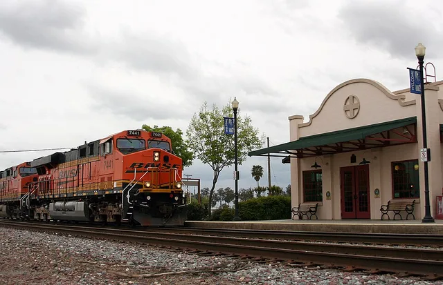 NB intermodal train passing the Amtrak station, Corcoran, California .