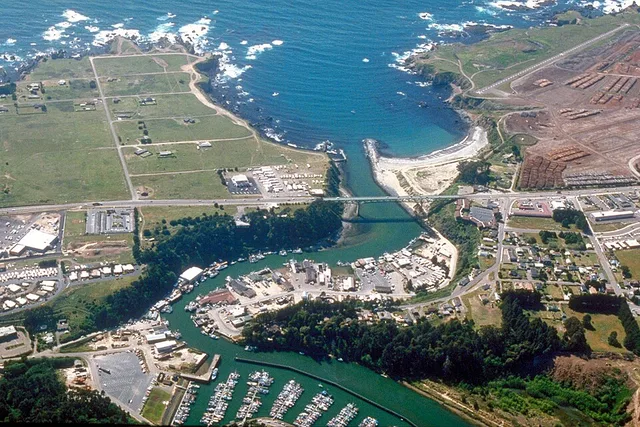 Aerial view of the mouth of the Noyo River on the Pacific Ocean at Fort Bragg, Mendocino County, California, USA. California State Route 1 (Main Street in Fort Bragg) crosses the...