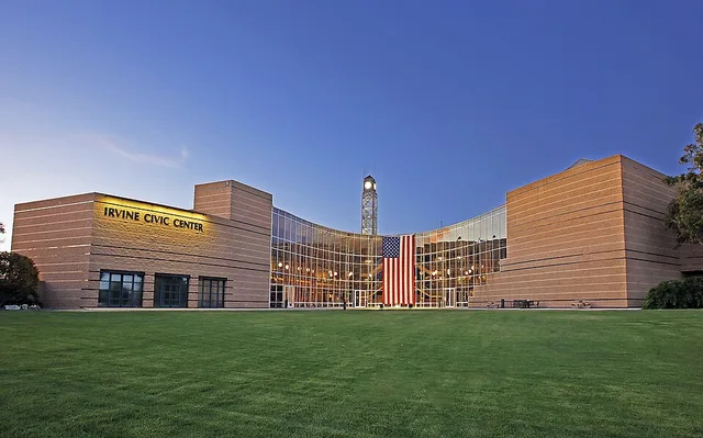 Irvine City Hall building displays American flag.