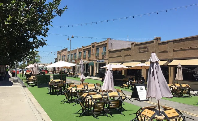 Outdoor dining seating in Placita Santa Fe in Old Town Placentia, California. View from West Santa Fe Street at South Bradford Street, lookin northwest. The photo has been taken i...