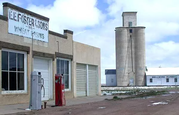 Former gas station and grain elevator tower in Nunn, Colorado , looking east from Logan Street towards U.S. Highway 85 .