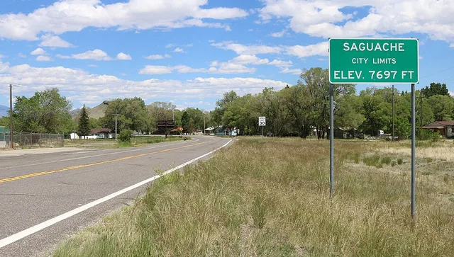 A city limit sign on the west side of Saguache, Colorado , along Colorado State Highway 114 .