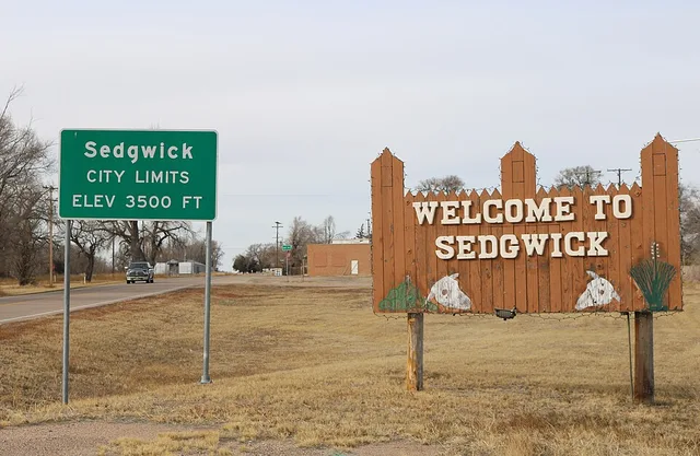 Two signs marking the entrance to Sedgwick, Colorado, in Sedgwick County. The road on the left is U.S. Route 138.