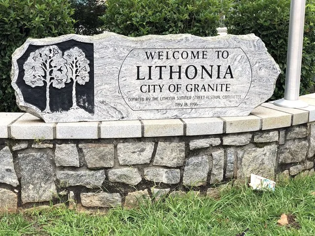 Granite sign at the corner of Main Street and Max Cleland Boulevard in downtown Lithonia, Georgia welcoming visitors to the town.