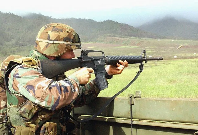 Specialist Kenneth Bull fires his M16 rifle from the back of a truck during recent convoy live-fire training at Schofield Barracks, Hawaii. Bull is assigned to the 25th Infantry D...
