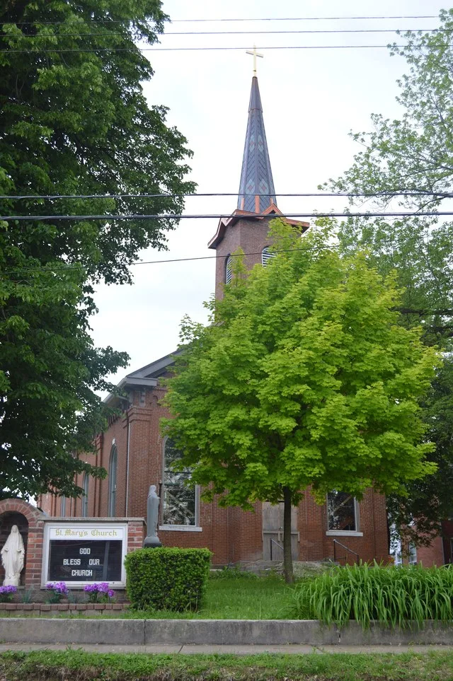 Front and eastern side of St. Mary's Catholic Church, located at 115 E. Main Street in Brussels , Illinois , United States . Built in 1902, it is part of the Brussels Historic Dis...