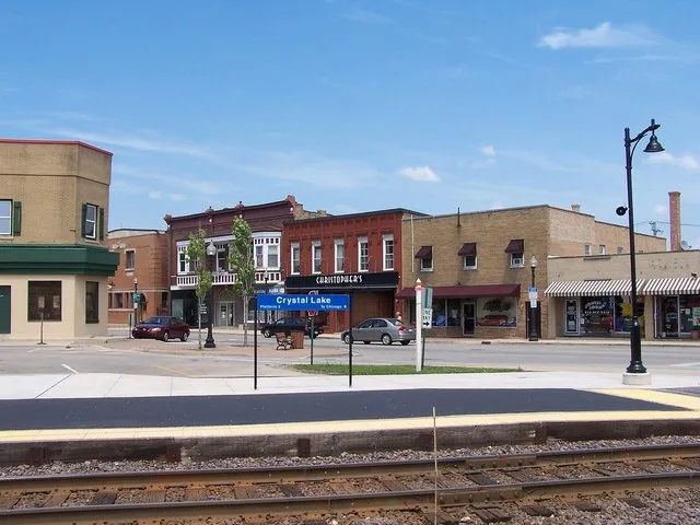 View of businesses on Main Street in Crystal Lake, Illinois. Camera is looking north across Metra railroad tracks.
