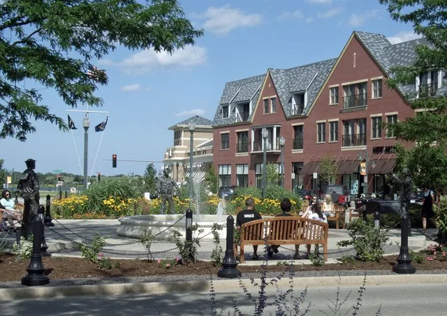 main plaza, functionally a traffic island. Bronze sculptures and decorative programming call attention to its history as a former Naval Air Station terminal. The "main street" pro...