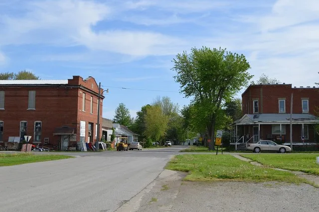 Looking northward on Missouri Street at the Sixth Street intersection in Hindsboro , Illinois , United States . The brick building on the left was constructed in 1910.