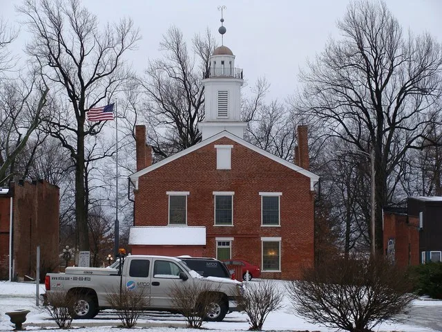 Rear of Metamora Courthouse State Historic Site seen from East Chatham Street in Metamora, Illinois , USA. In the foreground, the parking lot and utility trucks for Metamora Telep...