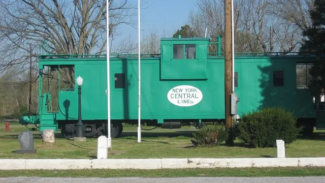 Former New York Central caboose by the former depot in downtown Olmsted , Illinois , United States .