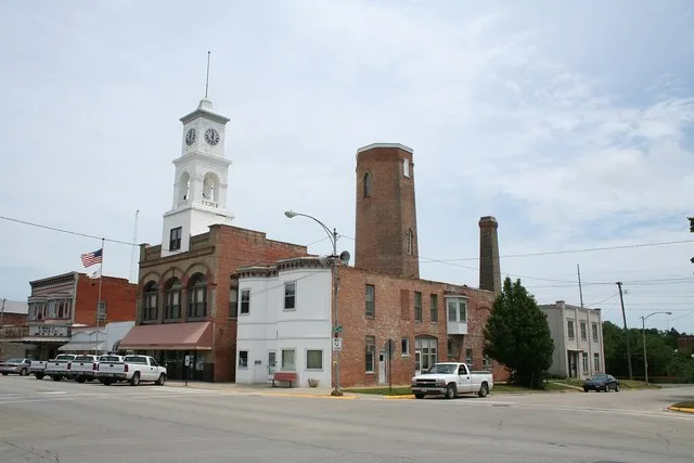 Paxton_Illinois_corner of Market_and_Center. City Hall with clock tower and historical water tower behind it. The Majestic Theatre on the far left was destroyed by fire on Novembe...