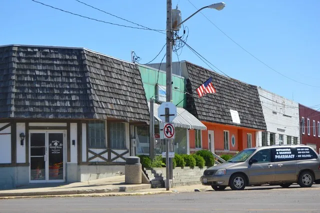 Buildings on the northern side of Broad Street, seen looking east from the Main Street intersection, in Roanoke , Illinois , United States .