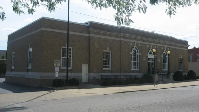 Front and eastern side of the Robinson Post Office, located at 101 E. Walnut Street on Courthouse Square in Robinson , Illinois , United States .