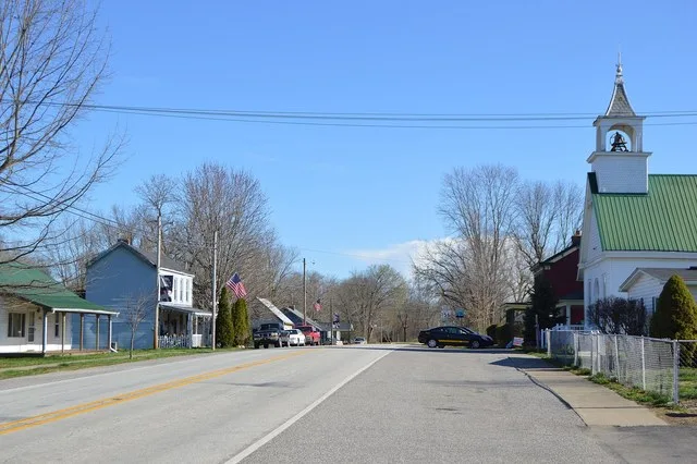Houses and a church on Main Street ( State Road 156 ), seen looking northeast from the Third Street intersection, in Patriot , Indiana , United States .