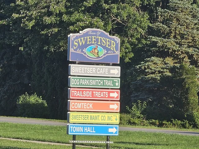 Sign welcoming people to Sweetser, Indiana and providing helpful navigation
