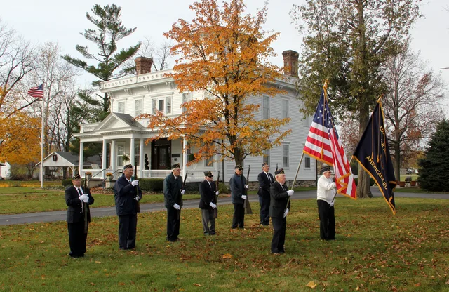 Legionnaires stand near the Wolcott House in Wolcott, Indiana during the 2011 Veterans Day ceremony. Photo looks southwest from near North Range Street.