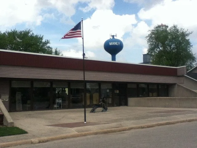 Photo of the Manly Public Library with one of the town's water towers in the background.