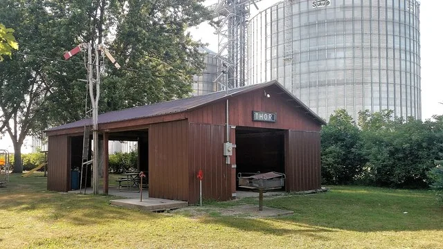 Park along the former railroad line (now Three Rivers Trail) and park pavilion with former railroad signage in Thor