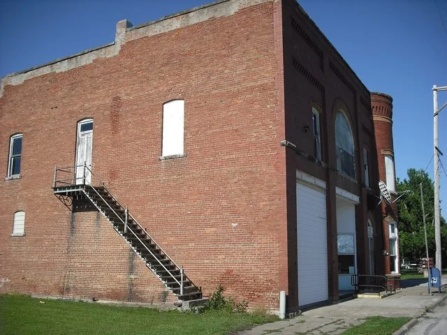 The large building in the center of Powhattan, Kansas which houses the Post Office and a couple other civic businesses.