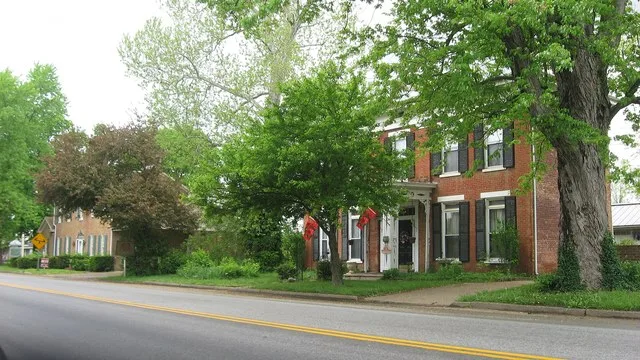 Buildings on the northern side of Main Street ( U.S. Route 42 ) on both sides of the Ann Street intersection in Ghent , Kentucky , United States . These houses (the closer of whic...