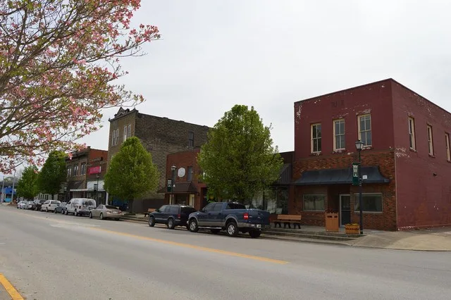 Eastern side of Main Cross Street ( Kentucky Route 2566 ) across from the Lawrence County Courthouse in downtown Louisa , Kentucky , United States . This block is part of the Loui...