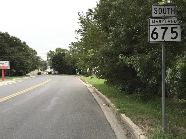 View south along Maryland State Route 675 (Bi State Boulevard) at Maryland State Route 54 and Delaware State Route 54 (State Street) in Delmar, Wicomico County, Maryland