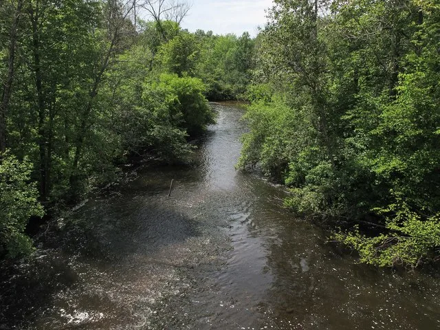 The Little Muskegon River as viewed downstream from a bridge on the White Pine Trail in Morley, Michigan .
