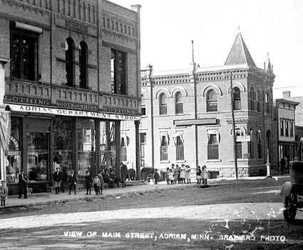 1910 postcard of Main Street in Adrian, Minnesota, United States. Published by Branberg Photo of Minnesota. The brick building on the right is the 1891 Queen Anne style Adrian Sta...