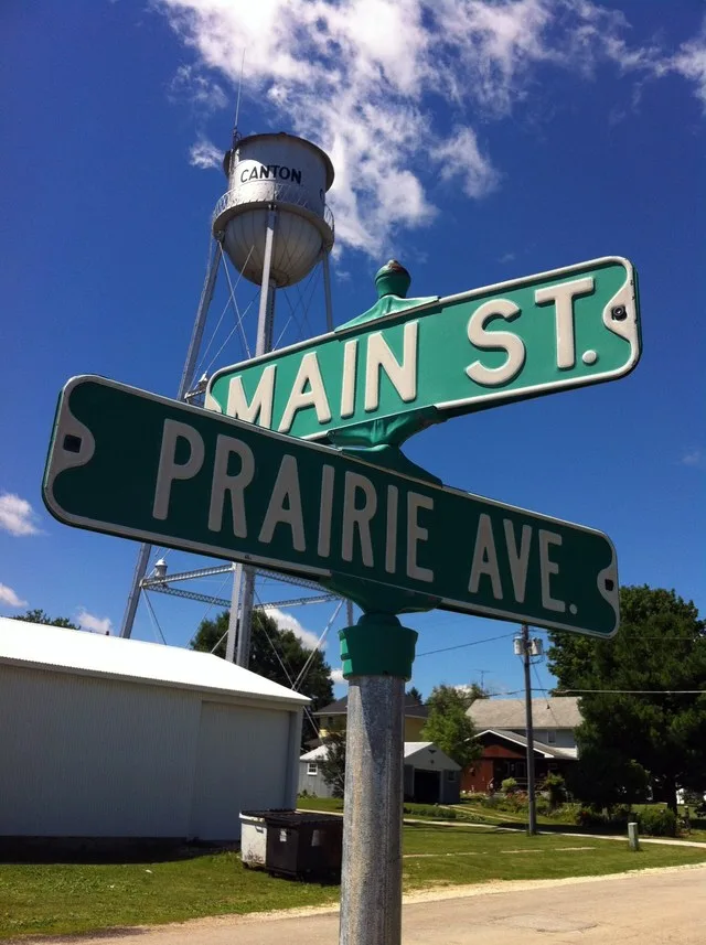 Street signs - Prairie Avenue and Main Street, with water tower in the background. Canton, Minnesota, United States.