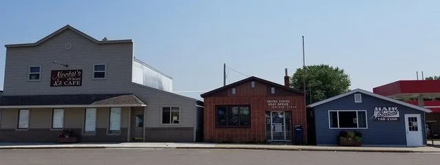 Businesses on Main Street in Dent, Minnesota, including Nootzi's On Main cafe, the US Postal Service, and Hair Central salon