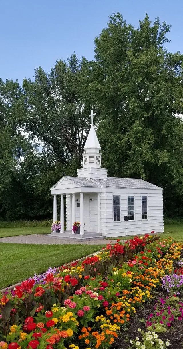 Small one-room chapel which mimics the shape of a larger church, with a columned portico and a steeple. Chapel is located in Morning Glory Gardens, along the shore of Lake Minnewa...