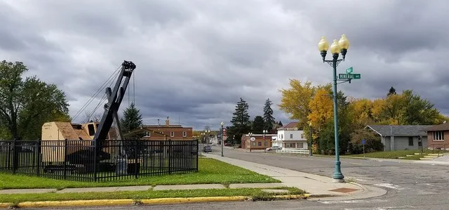 The intersection of Mineral Avenue and Main Street in Mountain Iron, Minnesota. Retired mining equipment is displayed in a city park.