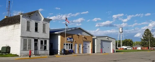 Buildings along McKinley Avenue in Shelly, Minnesota, including the post office. The Shelly water tower is also visible.