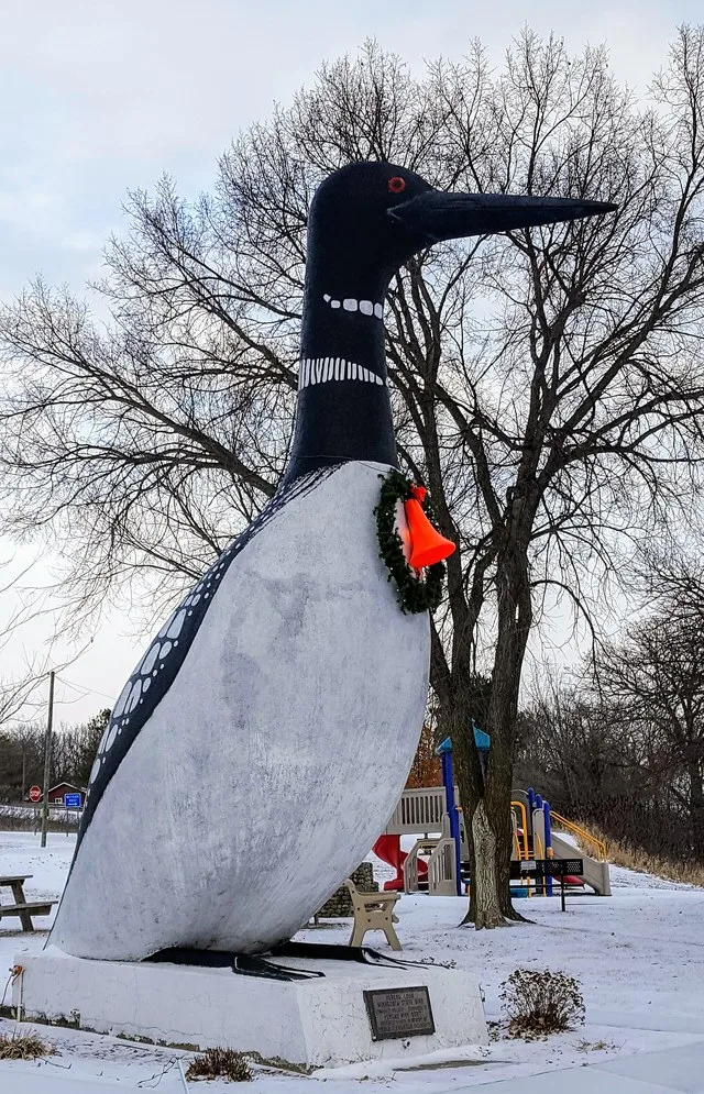 20 feet tall sculpture of a loon in Vergas, Minnesota, described as the world's largest loon. The sculpture is decorated with a wreath and bell for the Christmas holiday.