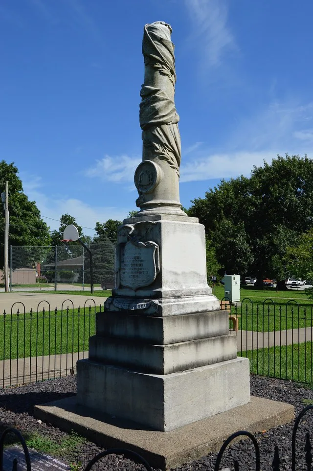 Northern and western sides of the Civil War monument in the public square park in La Grange , Missouri , United States . "1864" is the date of the monument's placement: Lewis Coun...