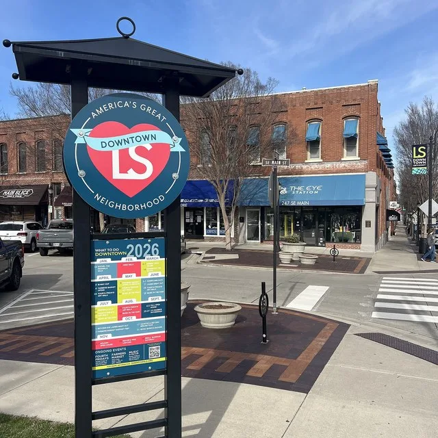 Informational kiosk for downtown Lee's Summit on the corner of Main Street and Third Street, with storefronts of local businesses in the background