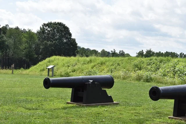 Cannons at the Battle of Pilot Knob State Historic Site with the site of Fort Davidson in the background. June 2026