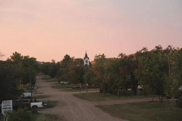 Downtown Nashua, Montana, at sunset from the Empire Builder train. The church in the middle of the photo is Queen of Angels Catholic Church.