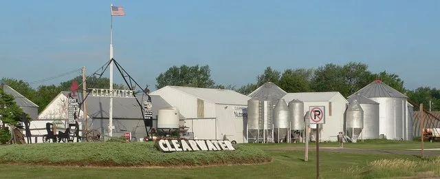 Grain bins and welcome signs at north edge of Clearwater, Nebraska , on south side of U.S. Highway 275 .