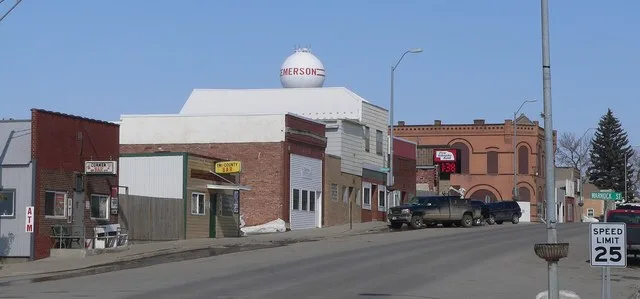 West side of Main Street ( Nebraska Highway 9 ) in Emerson, Nebraska . The First Nebraska Bank building is on the southwest corner of First and Main, at the junction of the lines...