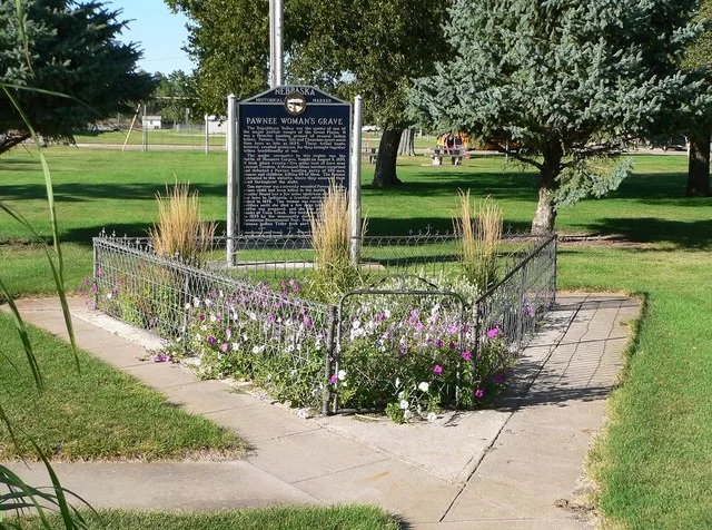 Park in Indianola, Nebraska . The blue sign is a Nebraska historical marker, commemorating the burial of a Pawnee woman who was fatally wounded in the 1873 battle with the Sioux a...
