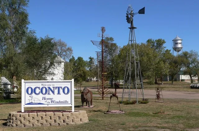 Welcome sign, sculptures, and windmill in Oconto, Nebraska .