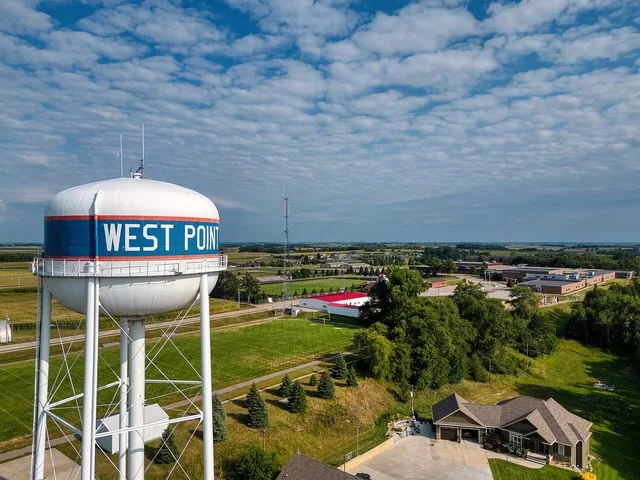Aerial view of water tower in West Point, NE with West Point Beemer Jr-Sr High School in the distance.